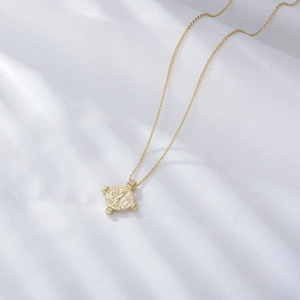 Collier médaille César en argent S925 doré sur fond de tissu drapé blanc élégant