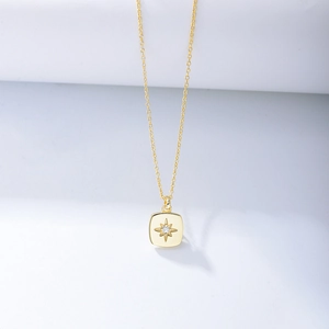 Detailed macro of golden starburst pendant necklace with a clear cubic zirconia center