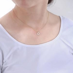 Close-up of a s925 silver hexagram star pendant with sparkling zircon worn by a model
