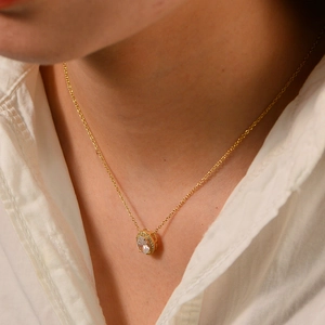 Close-up of elegant s925 silver gold necklace with oval zircon pendant on a model