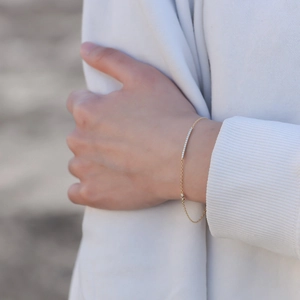Elegant gold chain bracelet with a sparkling row of pavé diamonds on a female wrist