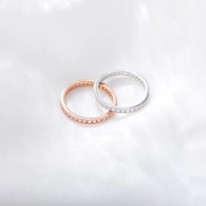 Macro view of stacked s925 silver and rose gold eternity rings with cubic zirconia