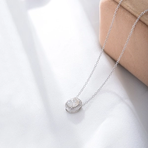 Macro shot of silver S925 oval pendant with pavé zirconia on elegant silk background