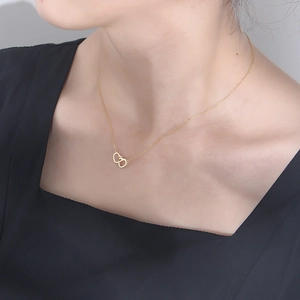 Close-up of interlocking heart necklace with zircon inlay on model's neck