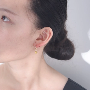 Detail of s925 silver gold-plated pineapple earrings with yellow rectangular zircon