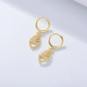 Macro view of gold fishbone earrings with pave-set zircon stones and polished finish