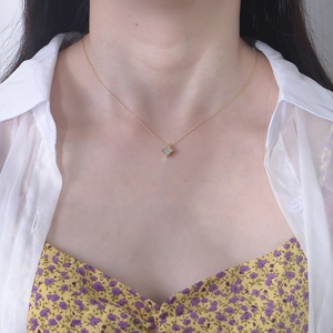 Detail of a geometric square zircon pendant necklace on neck for an elegant gold look