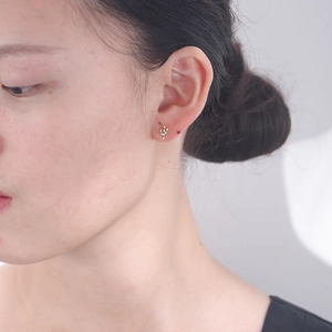 Gros plan de boucles d'oreilles cactus en argent s925 avec zircons verts sur modèle