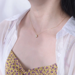 Close-up of a gold square geometric pendant necklace with zircon inlay on a model
