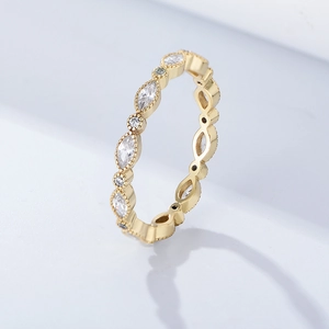 Macro detail of gold eternity ring with marquise and round stones and milgrain edges