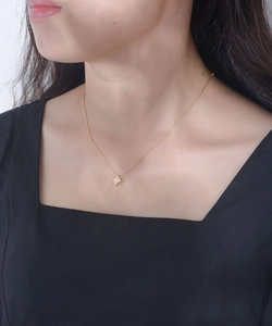 Detail of a gold geometric star pendant with sparkling cubic zirconia on a female neck