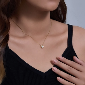 Close-up of minimalist 925 sterling silver gold-plated necklace with a zircon pendant