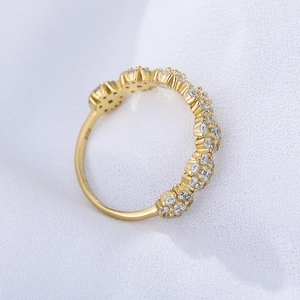 Macro d'une bague ondulée en argent 925 avec zircons sertis sur fond de soie bleu doux