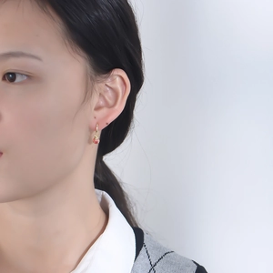 Gros plan de boucles d'oreilles coccinelle en argent s925 portées avec détails en émail