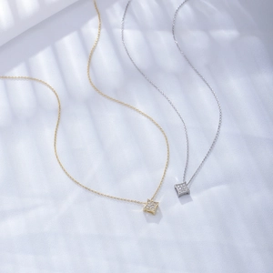 Macro detail of geometric square pendants with sparkling zircons in gold and silver finish