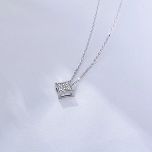 Detail of square silver pendant necklace with sparkling pavé zircons on blue silk