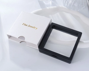 Detail of white jewelry sleeve with gold text and black PE film floating display frame