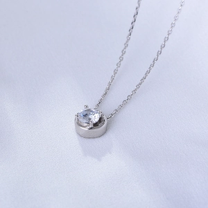 Macro shot of a minimalist 925 sterling silver necklace with a sparkling round zircon stone