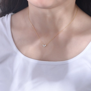 Close-up of a minimalist gold V-shaped necklace with three sparkling round stones for women