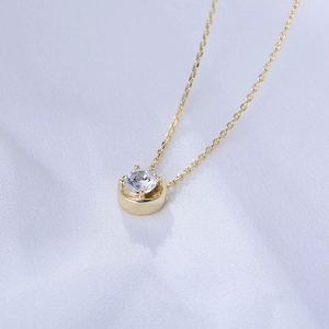 Macro shot of gold-plated 925 silver necklace with sparkling round zircon pendant
