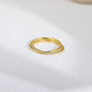 Bague croisée dorée à double couche avec oxydes de zirconium scintillants sur fond blanc pur