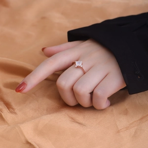 Detail of rose gold moonstone ring with beaded band texture on satin background