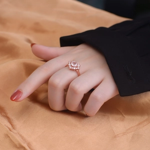 Rose gold ring with pink quartz on elegant champagne silk and black suit background