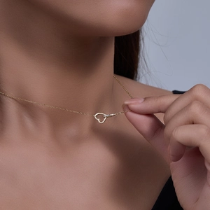Detail of interlocking heart necklace with pavé zircons worn on woman's neck