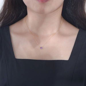 Minimalist gold necklace with a rectangular purple amethyst pendant worn on the collarbone