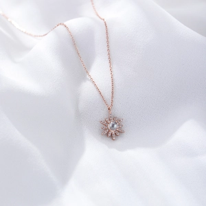 Collier soleil en or rose avec opale centrale et halo de zircons sur soie blanche