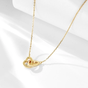 Close-up of interlocking gold heart pendant featuring sparkling pavé zircon stones