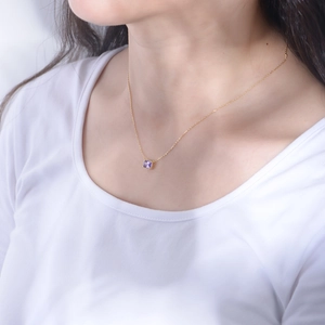 Macro detail of a rectangular purple amethyst pendant on a fine gold-plated silver chain