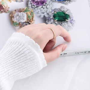 Close-up of a slim gold ring with small pavé zircons worn on a finger
