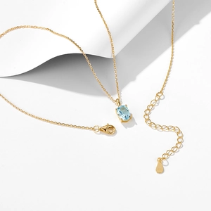 Detail view of gold-plated S925 silver necklace with oval light blue topaz pendant