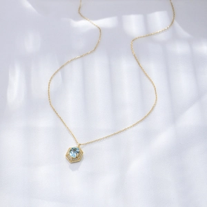 Detail der Goldkette mit sechseckigem Anhänger, blauem Topas und Pavé-Diamanten besetzt