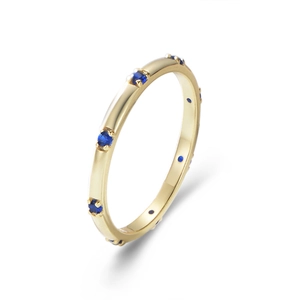 Close-up of a minimalist gold band ring featuring small blue round zircon stones
