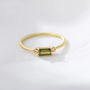 Macro shot of gold S925 silver ring featuring rectangular green zircon and side stones