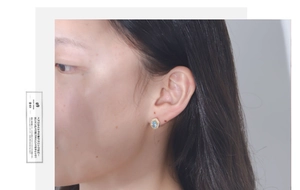 Detail of a hexagonal blue topaz earring with diamond halo on earlobe showing style
