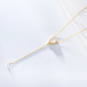 Détail macro du collier en or en Y avec quartz rose en forme de goutte et zircons