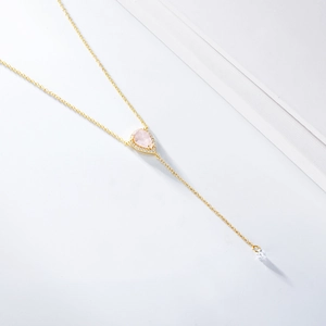 Détail d'un collier en Y doré avec quartz rose en goutte et pavage de zircons brillants