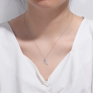 Silver crescent pendant necklace with turquoise stone on model's neck for elegant fashion