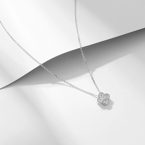 Dettaglio macro della collana con quadrifoglio in argento e zirconi pavé scintillanti