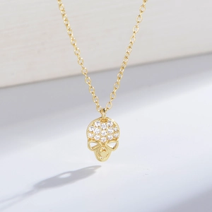 Macro detail of 18K gold S925 sterling silver skull pendant with sparkling white stones