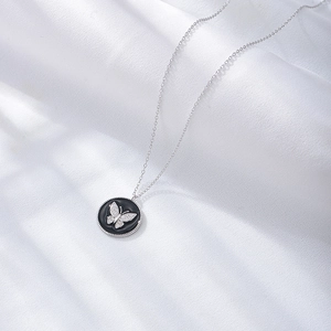 Macro view of S925 sterling silver butterfly pendant with diamonds on black enamel
