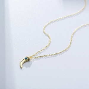 Gold plated crescent necklace with turquoise bead and cubic zirconia inlay detail