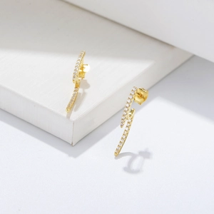 Macro detail of geometric gold S925 silver stud earrings with sparkling pave zircon stones