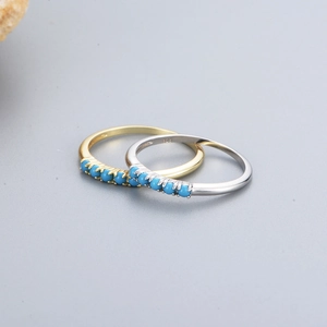 Macro detail of 925 silver rings set with turquoise stones in gold and silver plating