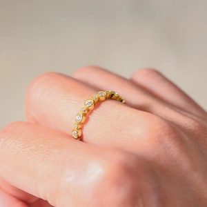 Macro shot of gold S925 silver ring featuring round cubic zirconia pavé setting on finger