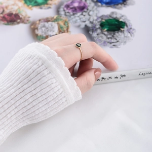 Detail of gold-plated S925 silver ring with black enamel and white zircon on a hand