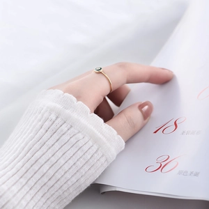Detail of s925 silver gold thin ring featuring a minimalist green enamel circular inlay